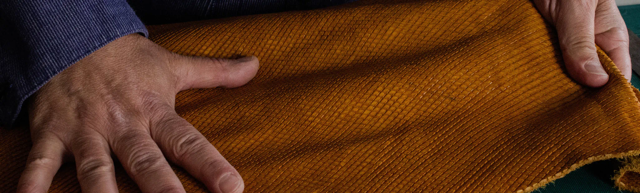 Hands working leather in the QUOYO atelier in Naples